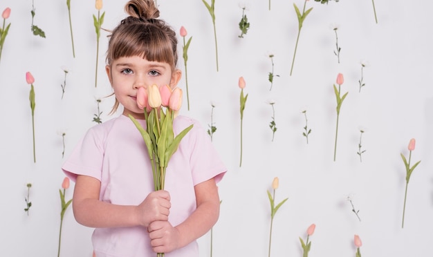 Photo gratuite adorable enfant avec tulipes coup moyen