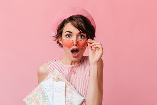 Adorable femme aux cheveux bruns avec des billets touchant des lunettes