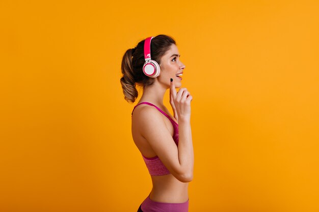 Adorable femme brune, écouter de la musique dans des écouteurs