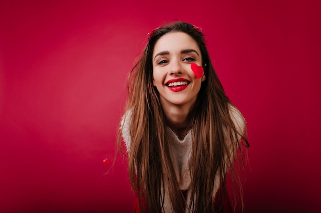 Adorable fille européenne aux cheveux longs exprimant le bonheur à la Saint-Valentin