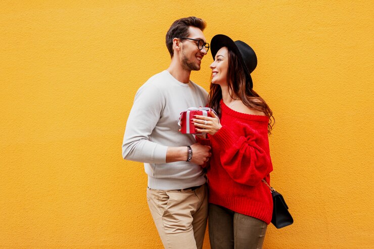 Photo gratuit adorable jeune couple amoureux. beau mec donne un cadeau à sa chérie