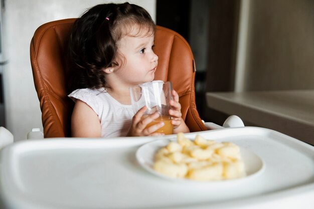 Adorable jeune fille buvant du jus