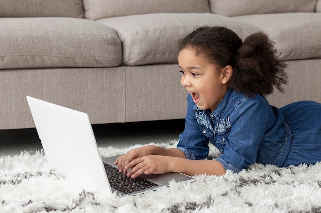 Adorable jeune fille parcourant un ordinateur portable