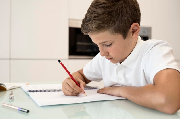 Adorable jeune garçon fait ses devoirs