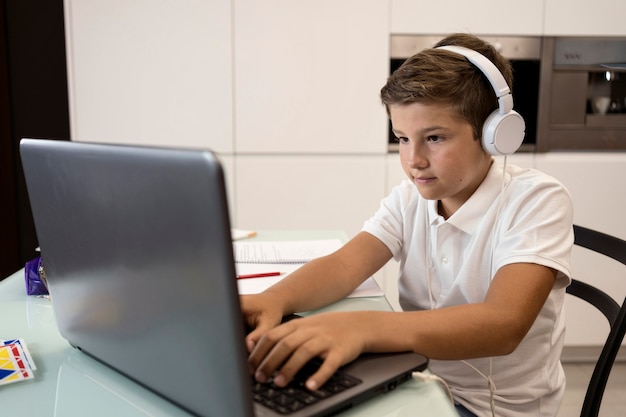 Photo gratuite adorable jeune garçon fait ses devoirs