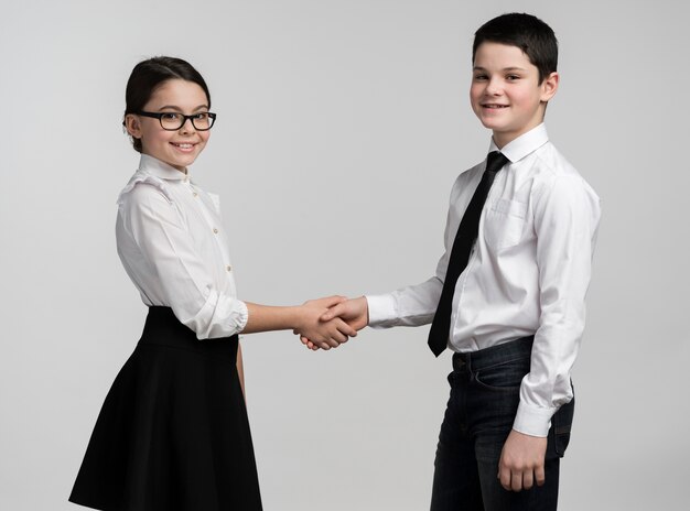 Adorable jeune garçon et fille se serrant la main