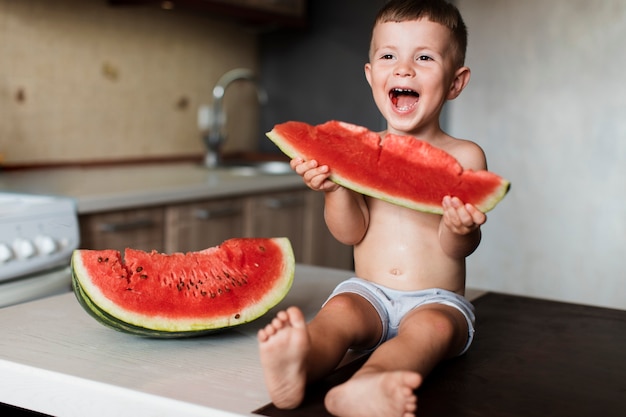 Adorable jeune garçon mangeant des pastèques