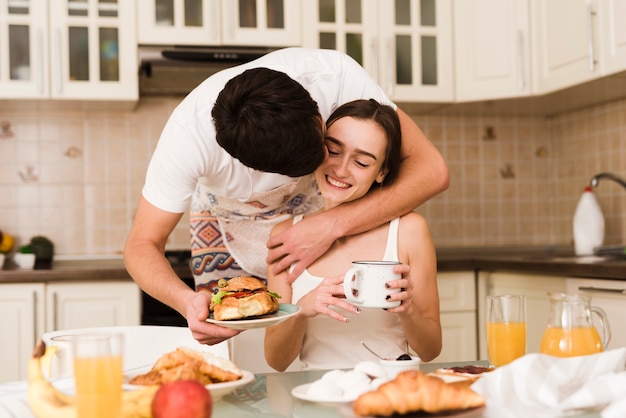 Adorable jeune homme servant le petit déjeuner avec sa petite amie