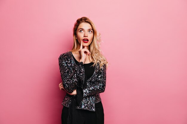 Adorable jolie fille aux lèvres rouges debout. Charmante femme mince posant en veste scintillante.