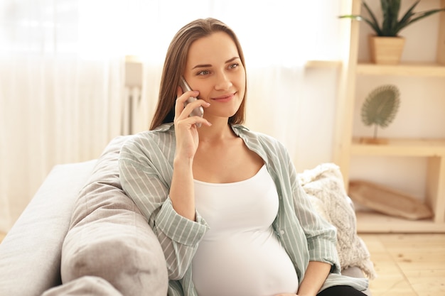 Adorable jolie jeune femme enceinte posant