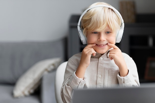 Photo gratuite adorable petit garçon faisant une séance d'orthophonie en ligne