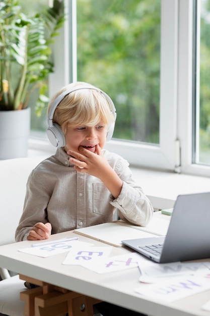 Photo gratuite adorable petit garçon faisant une séance d'orthophonie en ligne