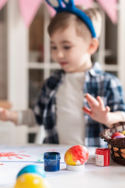 Photo gratuite adorable petit garçon jouant avec des oeufs de pâques