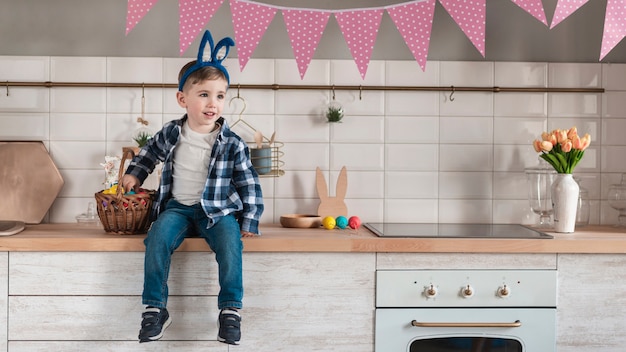 Photo gratuite adorable petit garçon avec des oreilles de lapin en détournant les yeux