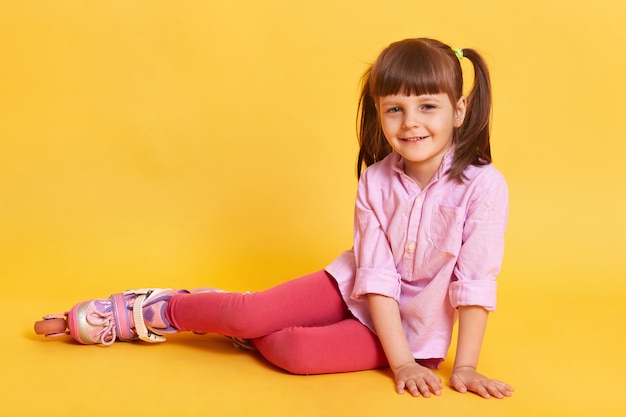 Adorable petite fille assise sur le sol.