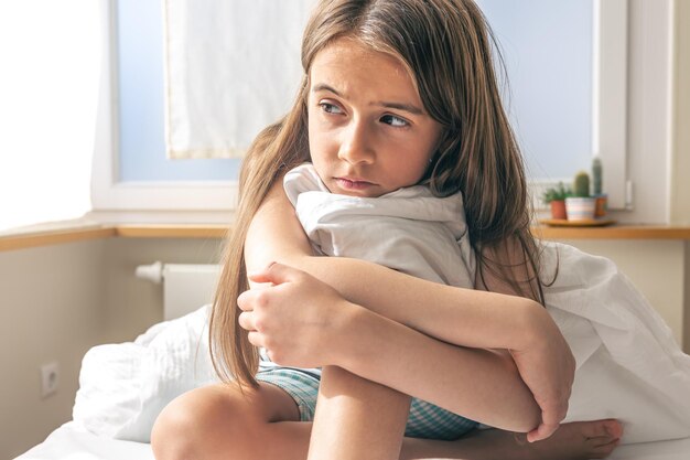 Adorable petite fille dans son lit tôt le matin