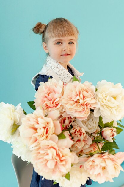 Adorable petite fille tenant des fleurs
