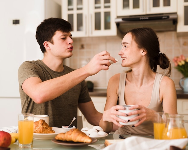 Adorables jeunes amoureux prenant le petit déjeuner