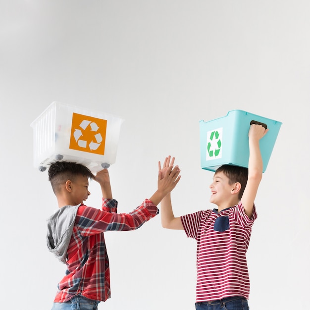 Photo gratuite adorables jeunes garçons tenant des boîtes de recyclage