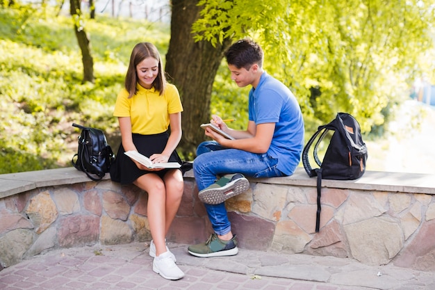 Photo gratuite ados stydying dans le parc