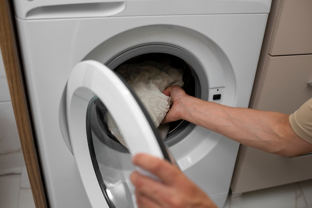 Adulte à angle élevé chargeant la machine à laver