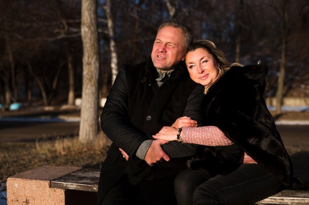 Affectueux couple de personnes âgées assis sur un banc