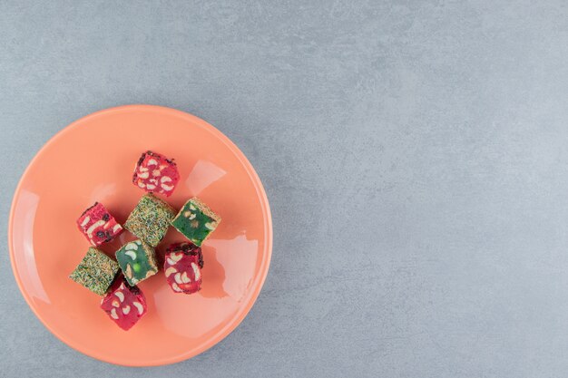 Un affichage de loukoums dans une assiette sur le fond de marbre. Photo de haute qualité