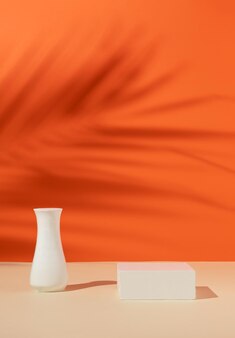 Affichage de produit moderne sur fond orange avec podium avec ombre de feuille de palmier tropical idée d'entreprise