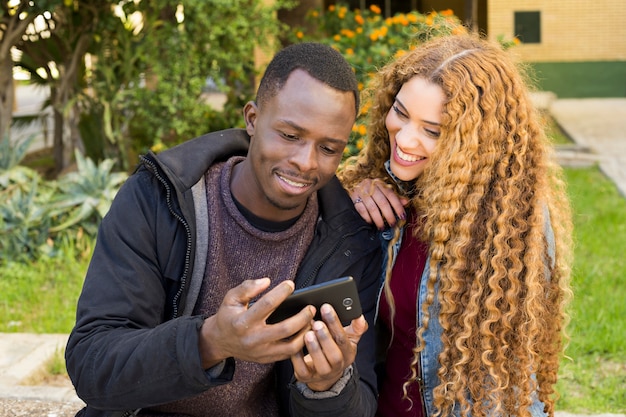 Photo gratuite afro américain couple regardant smartphone