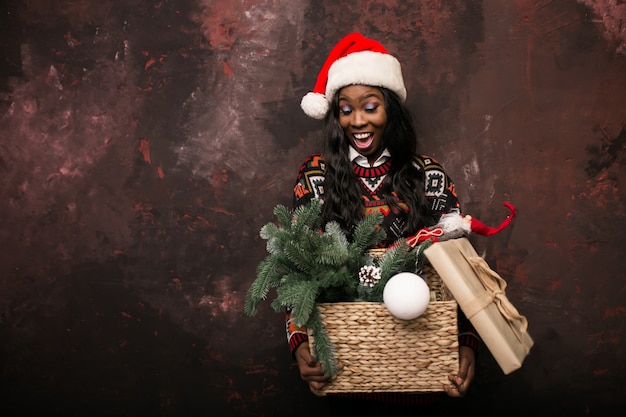 Photo gratuite afro américain fille tenant des décorations de noël dans une boîte