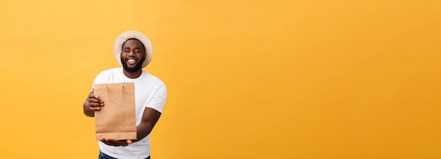 Photo gratuite afro-américain avec des sacs en papier coloré isolé sur fond jaune