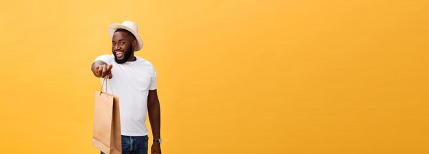 Afro-américain avec des sacs en papier coloré isolé sur fond jaune