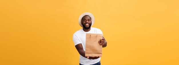 Afro-américain avec des sacs en papier coloré isolé sur fond jaune