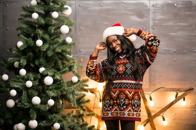 Afro américaine femme suspendue des jouets sur un arbre de Noël