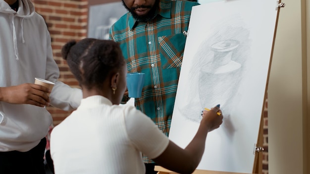 Photo gratuite les afro-américains dessinent l'inspiration du vase ensemble dans la classe d'art, en utilisant des outils artistiques et de la toile pour créer des croquis. activité créative pour développer de nouvelles compétences, pour dessiner des œuvres d'art modernes.