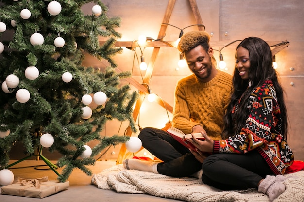 Afro couple américain assis près de l&#39;arbre de Noël