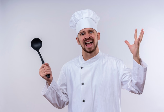 Agacé Chef Masculin Professionnel Cuisinier En Uniforme Blanc Et Cook Hat Holding Louche Levant Les Mains Avec Une Expression Agressive Se Sentir Irrité Debout Sur Fond Blanc