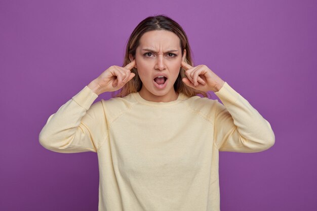 Agacé jeune fille gardant les doigts dans les oreilles