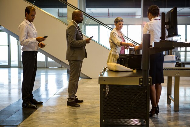 Agent d'enregistrement de la compagnie aérienne remettant la carte d'embarquement au passager