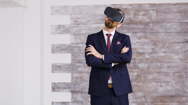 Photo gratuite agent immobilier en costume d'affaires utilisant des lunettes de réalité virtuelle dans un appartement vide.