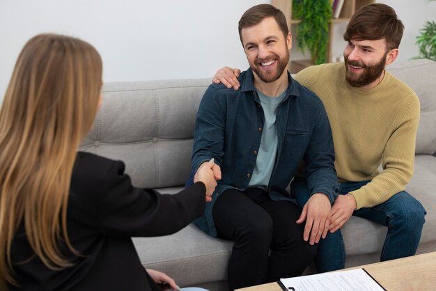 Agent immobilier féminin parlant affaires et montrant la maison à un couple gay