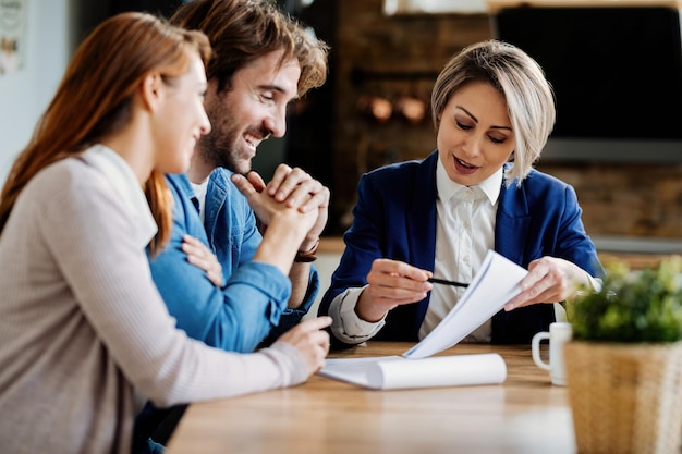 Photo gratuite agent immobilier et jeune couple passant par un contrat de location tout en ayant une réunion à la maison.