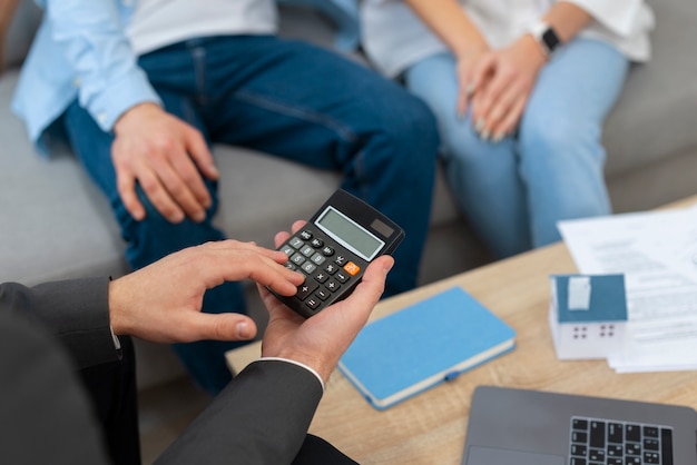 Agent immobilier masculin faisant des affaires et montrant la maison à un couple d'acheteurs potentiels
