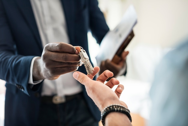 Agent immobilier remettant la clé de la maison à un client