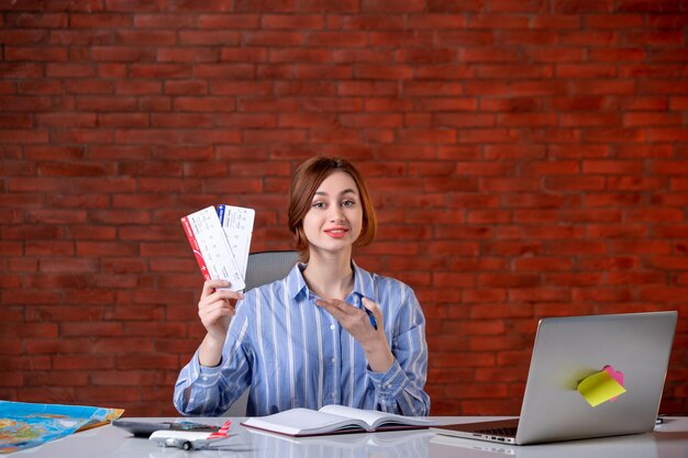 Agent de voyage vue de face assis derrière son lieu de travail avec service d'agence de billets d'avion gestionnaire mondial de l'opérateur carte du monde