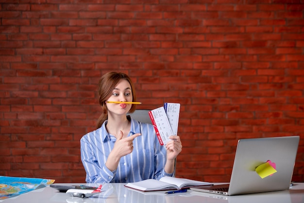 Agent de voyage vue de face derrière son lieu de travail avec des billets d'avion