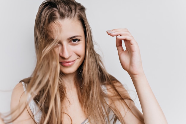 Agréable fille caucasienne aux cheveux brun clair isolés. Photo de magnifique modèle féminin en riant