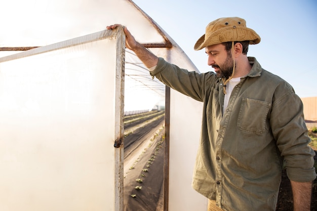 Photo gratuite agriculteur dans la serre de sa ferme