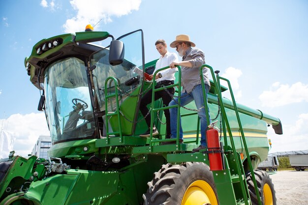 Un agriculteur avec un tracteur moissonneuse-batteuse dans un champ au soleil, des couleurs vives confiantes