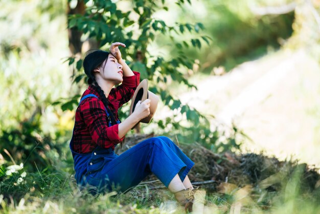 Agricultrice assise et fatiguée après la récolte